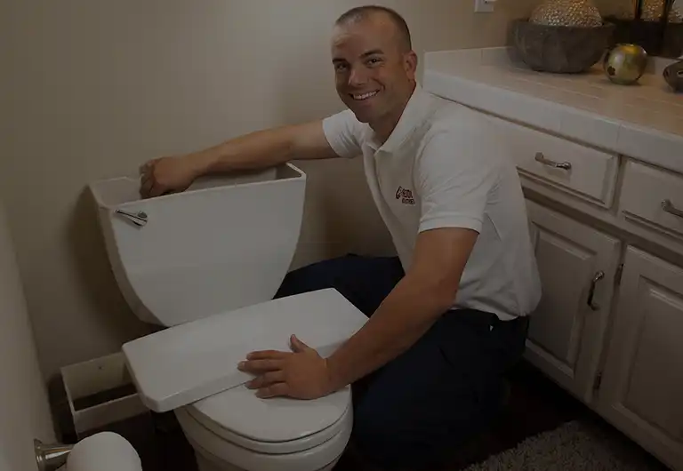 Professional Plumber Fixing Toilet